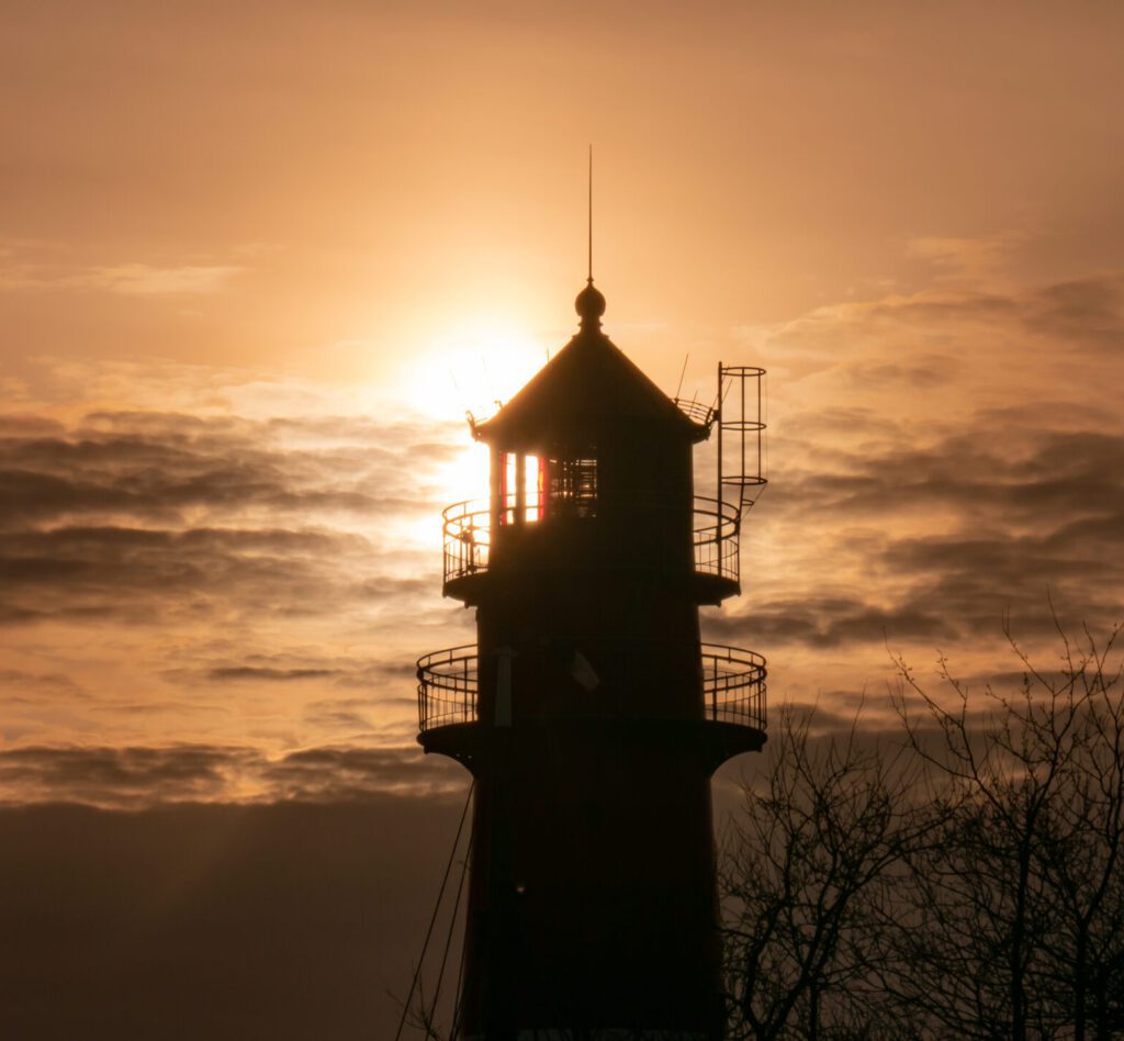 Nordseekerl- Über uns- Umwelt - Leuchtturm bei Sonnenuntergang